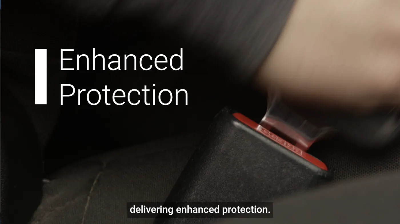 A seatbelt buckle clicking into its red housing, with the words Enhanced Protection set large over the frame