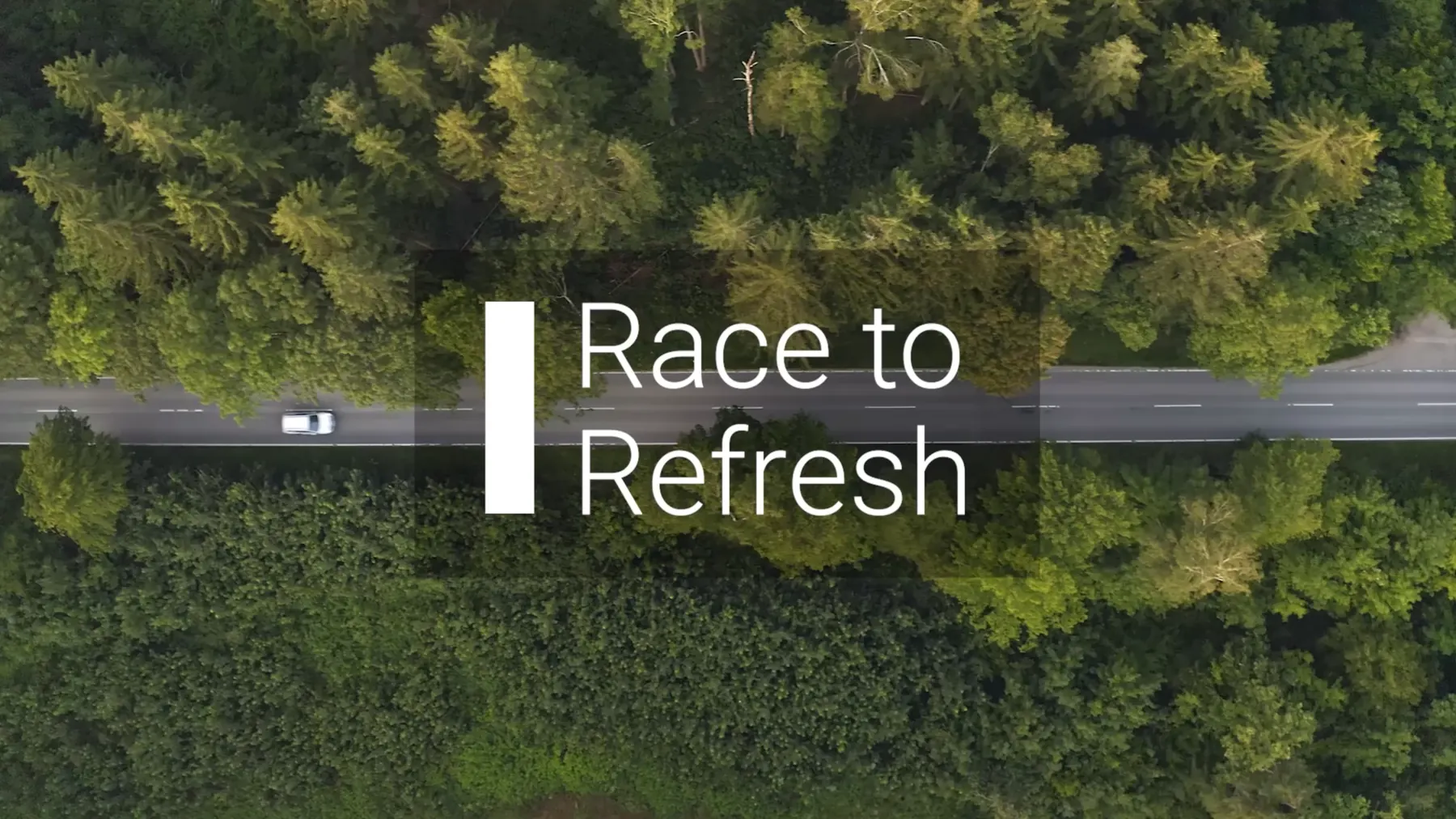 The Race to Refresh title card: an aerial shot looking straight down at a white car on a road cutting through dense forest, with the title set over it beside a tall white bar